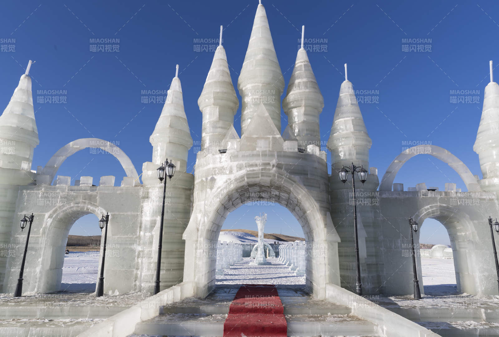 夕阳下雪原上晶莹剔透的冰雕建筑图片