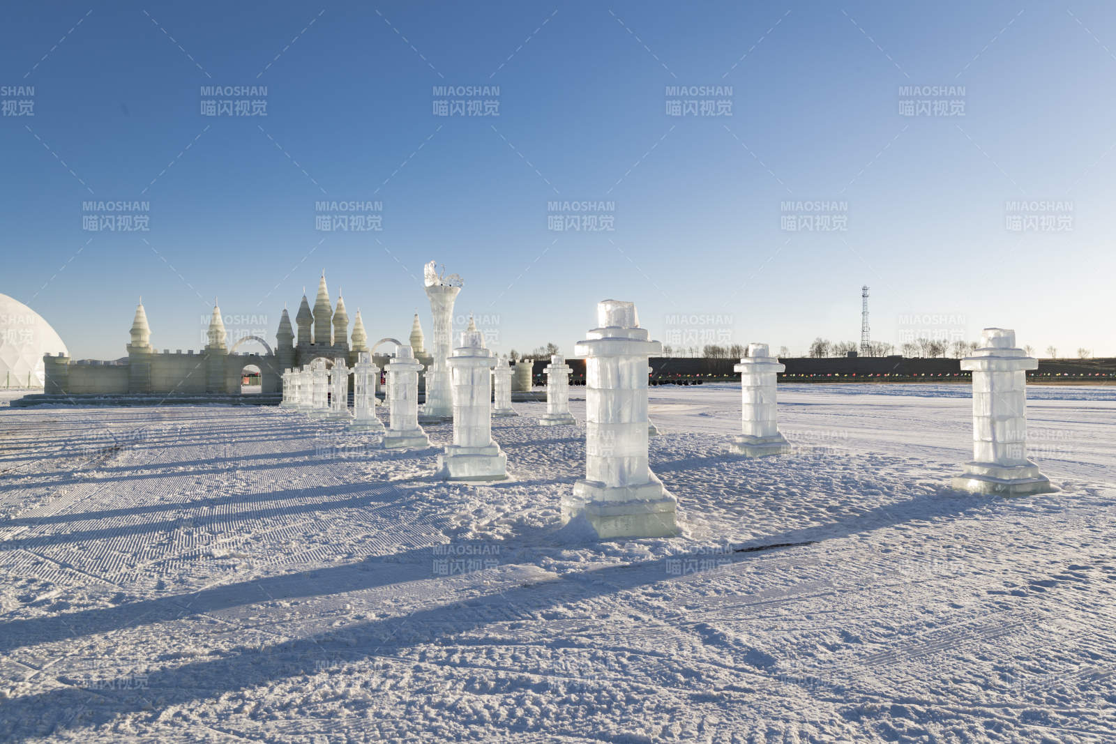 夕阳下雪原上晶莹剔透的冰雕建筑图片