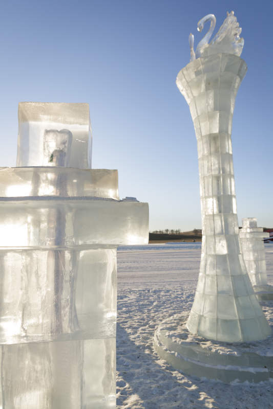 夕阳下雪原上晶莹剔透的冰雕建筑图片