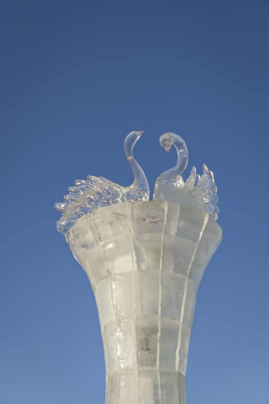 夕阳下雪原上晶莹剔透的冰雕建筑图片