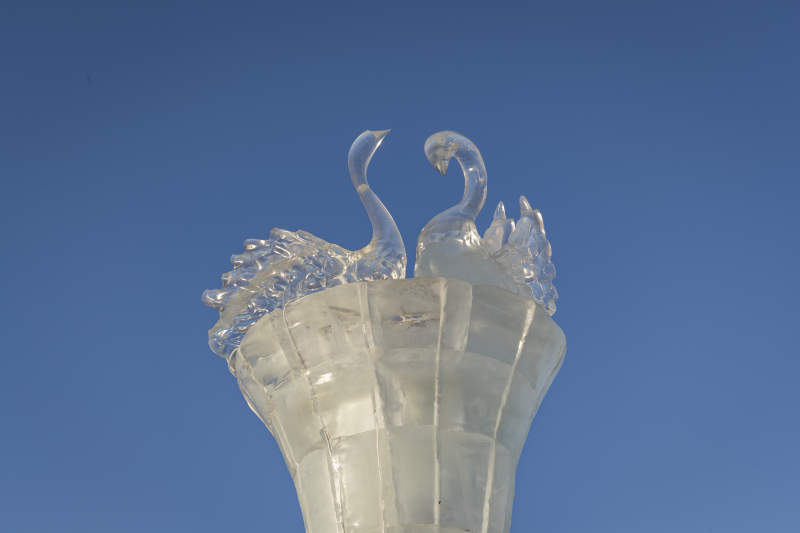 夕阳下雪原上晶莹剔透的冰雕建筑图片