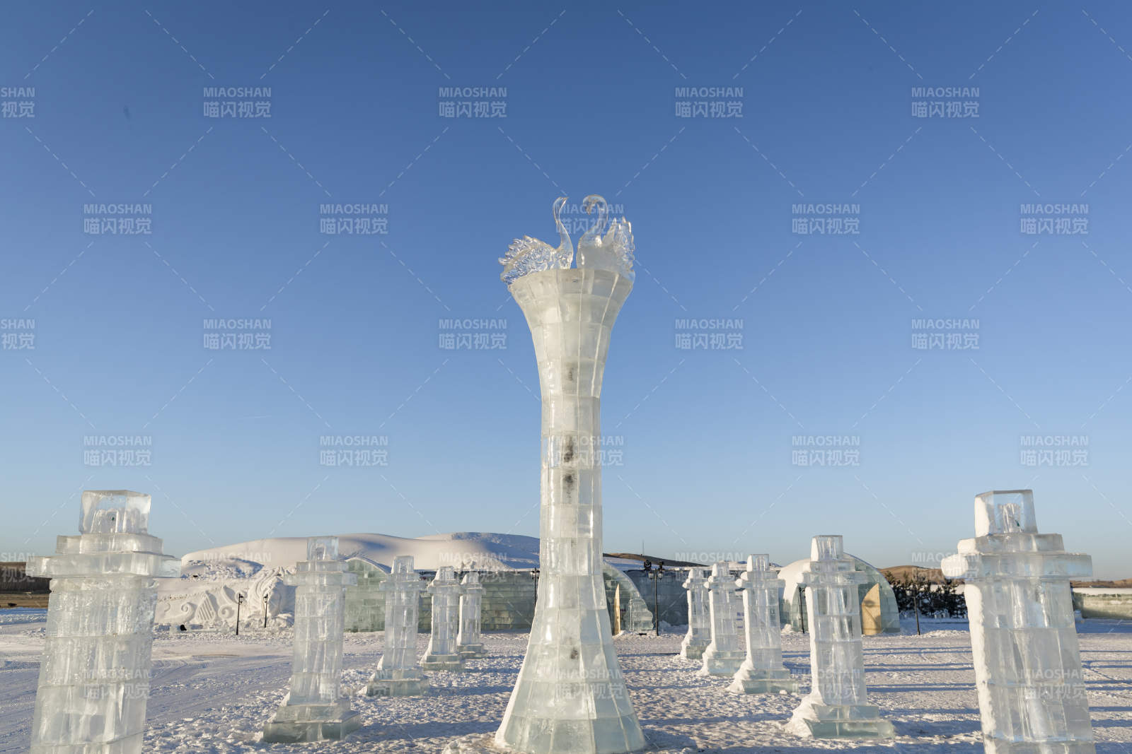 夕阳下雪原上晶莹剔透的冰雕建筑图片