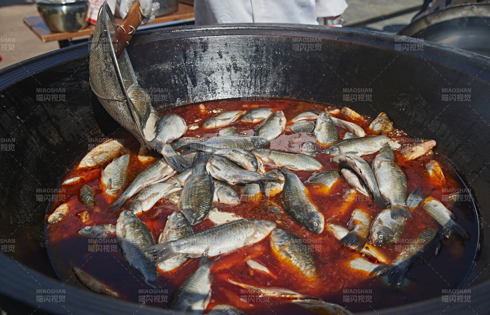 户外柴火铁锅炖煮的刚捕捞的野生鱼汤图片