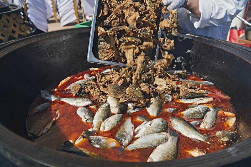 户外柴火铁锅炖煮的刚捕捞的野生鱼汤图片