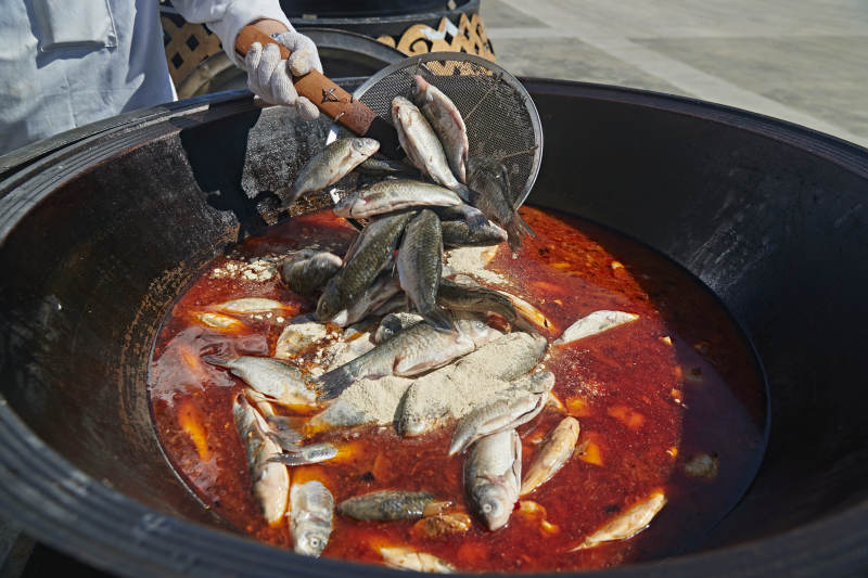 户外柴火铁锅炖煮的刚捕捞的野生鱼汤图片