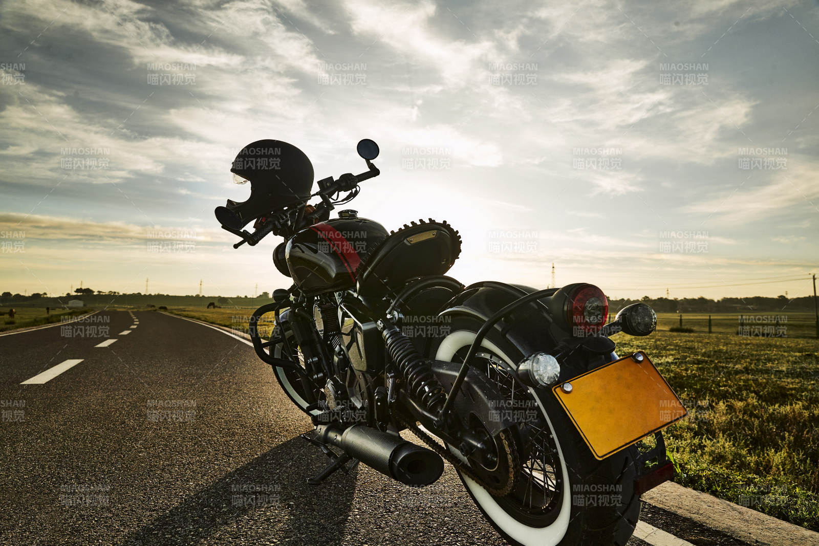 清晨朝阳下停靠在公路上的复古摩托车图片