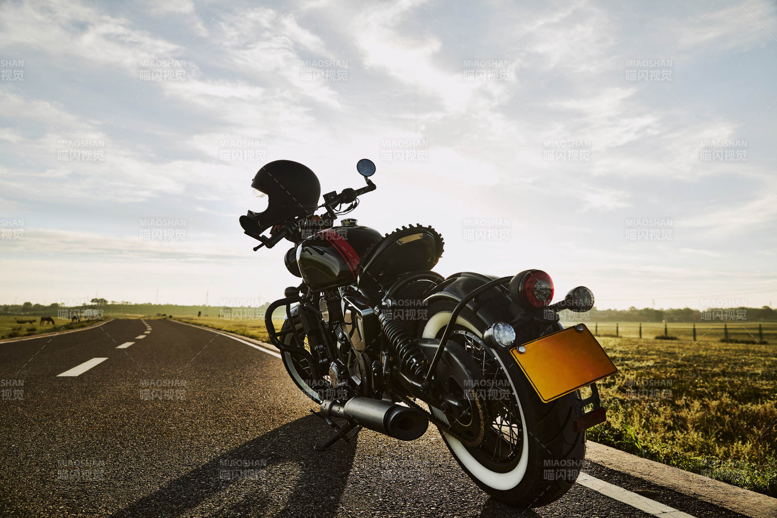 清晨朝阳下停靠在公路上的复古摩托车图片