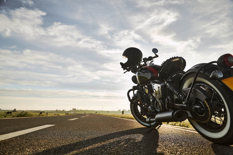 清晨朝阳下停靠在公路上的复古摩托车图片