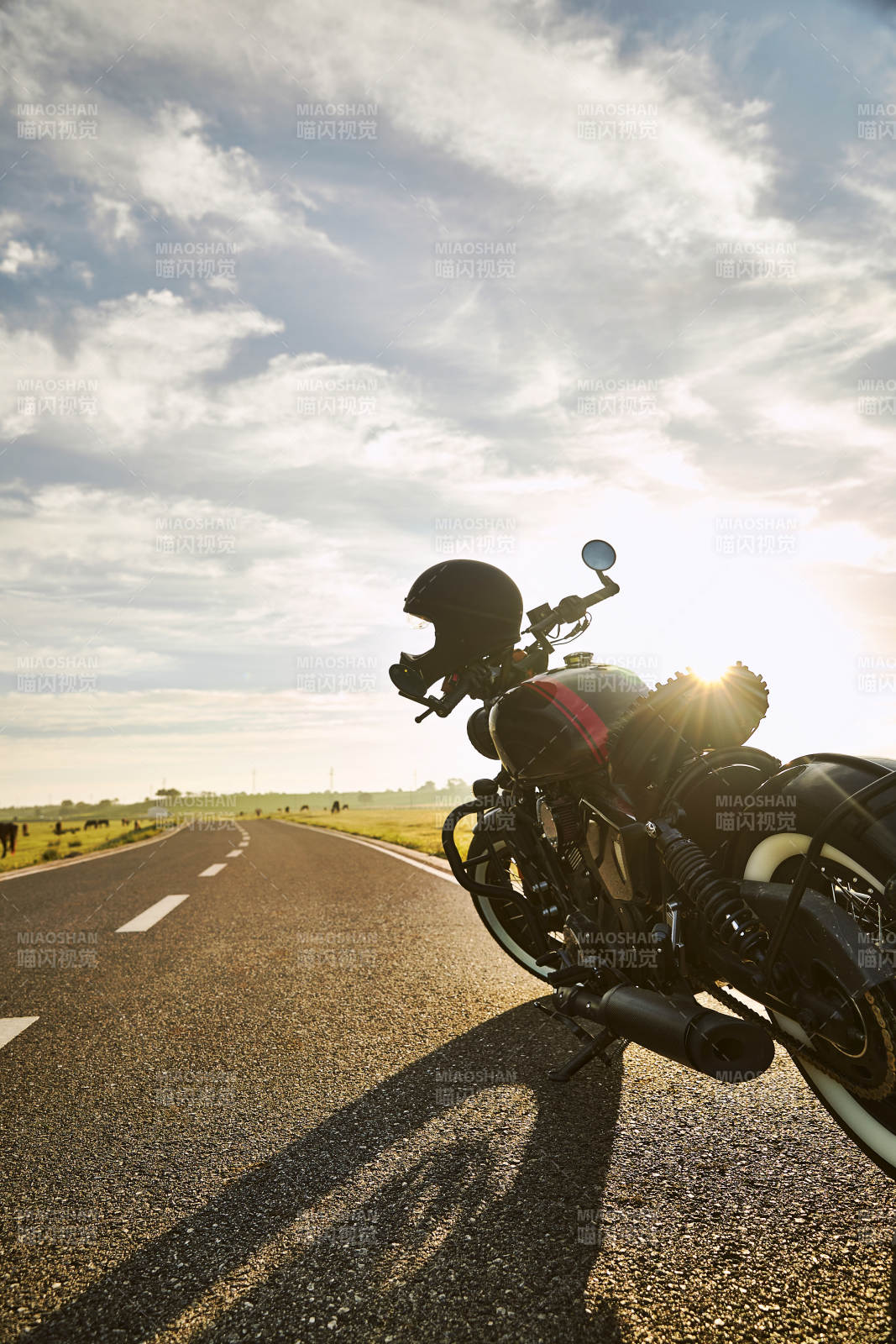 清晨朝阳下停靠在公路上的复古摩托车图片