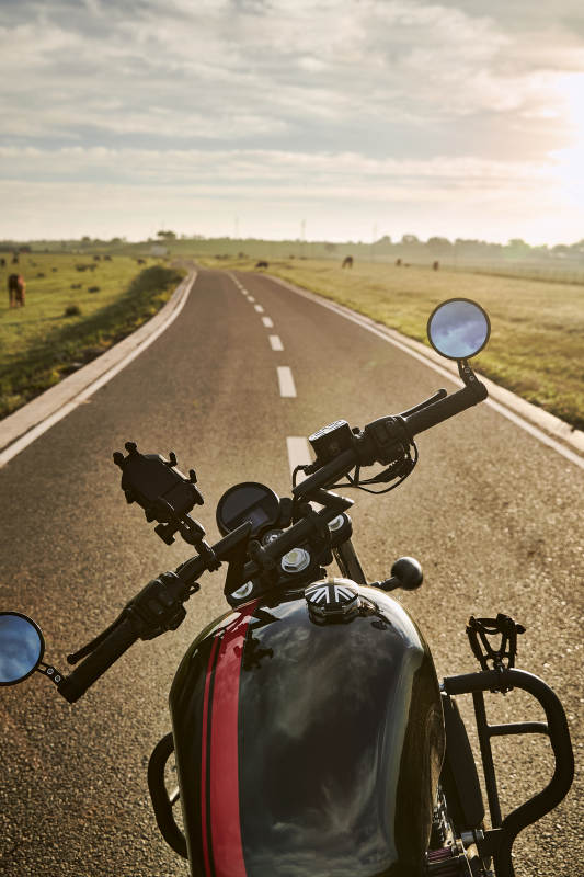 清晨朝阳下停靠在公路上的复古摩托车图片