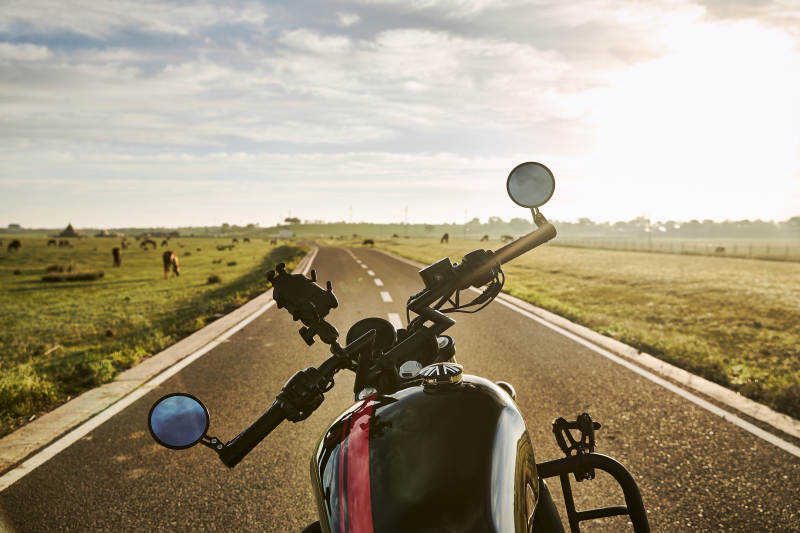 清晨朝阳下停靠在公路上的复古摩托车图片