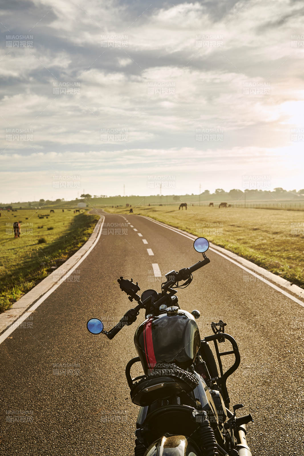 清晨朝阳下停靠在公路上的复古摩托车图片