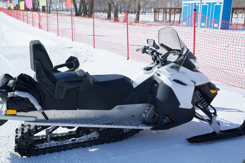 在雪地上停放的高级雪地摩托车图片