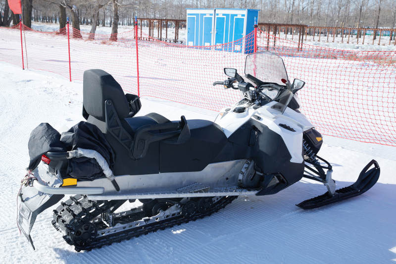 在雪地上停放的高级雪地摩托车图片