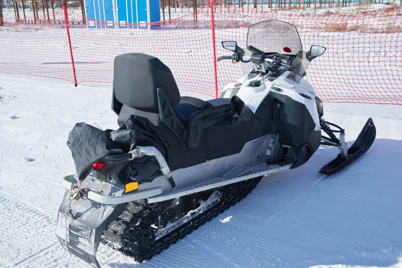在雪地上停放的高级雪地摩托车图片