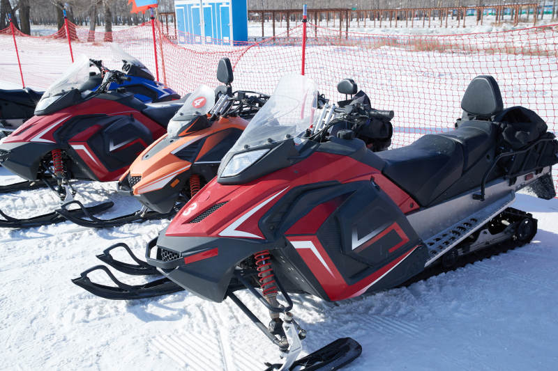 在雪地上停放的高级雪地摩托车图片