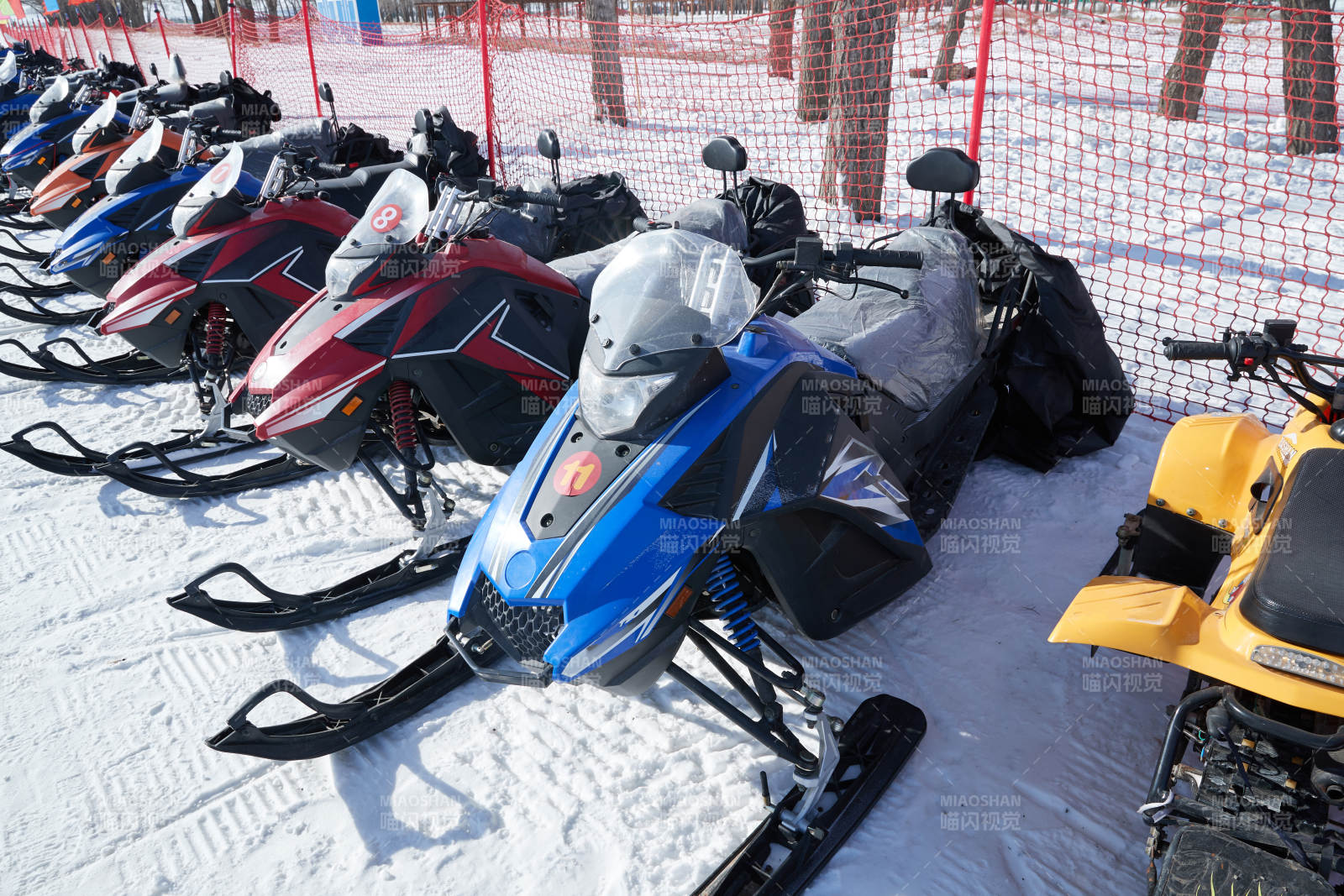 在雪地上停放的高级雪地摩托车图片