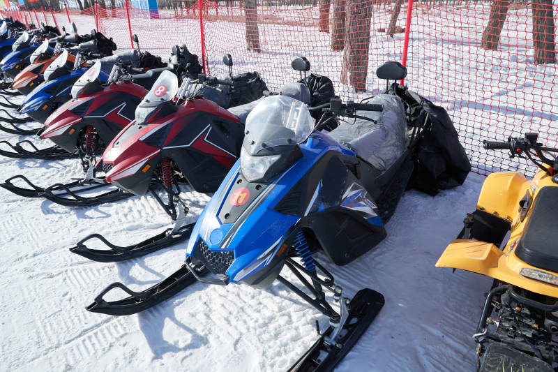 在雪地上停放的高级雪地摩托车图片