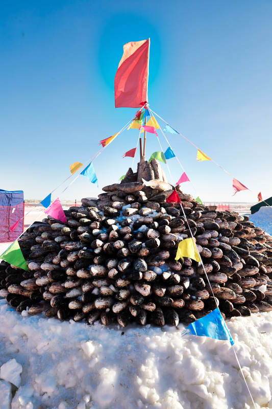 用冬捕野生湖鱼堆积的敖包图片