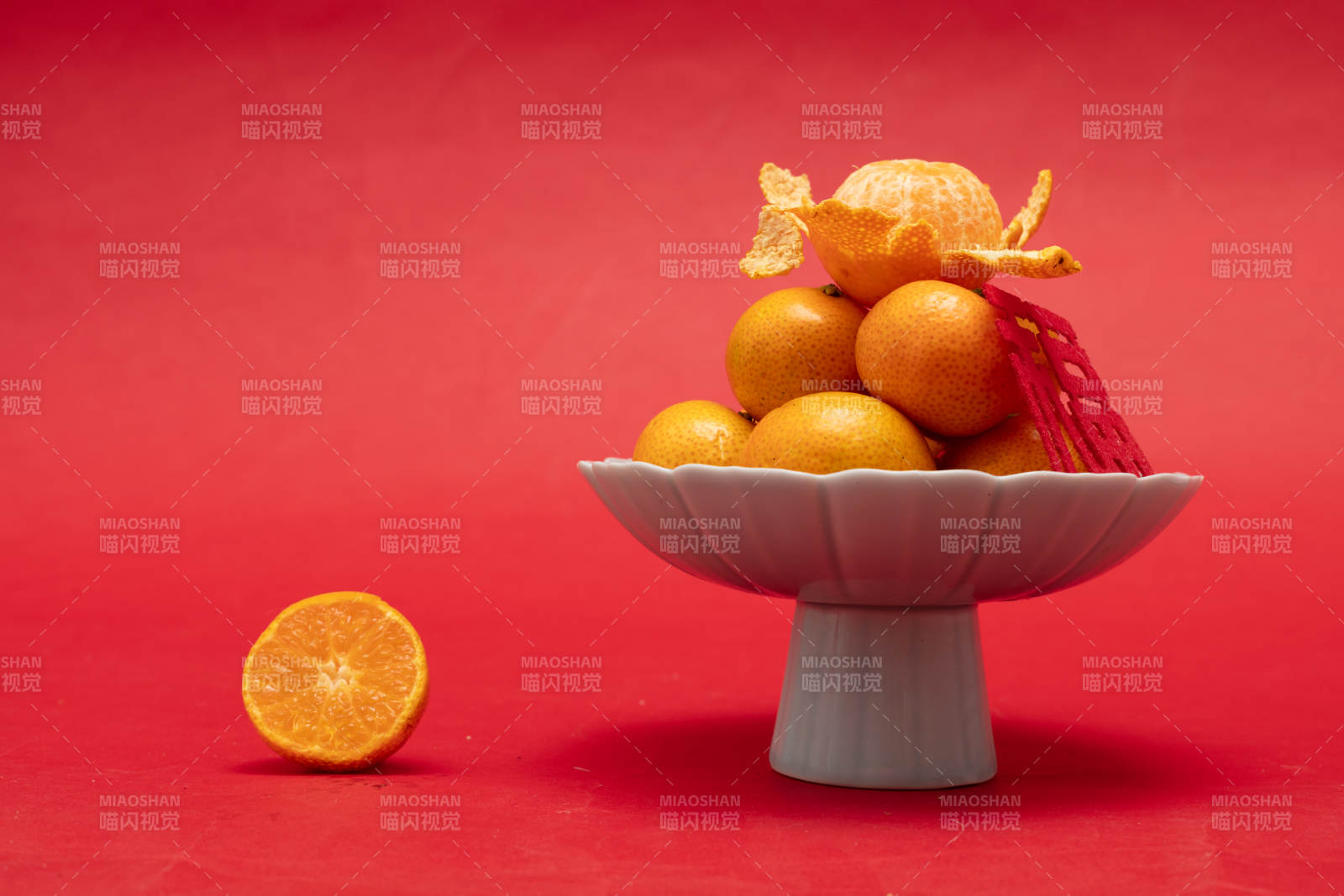 金桔堆盘红底映图片