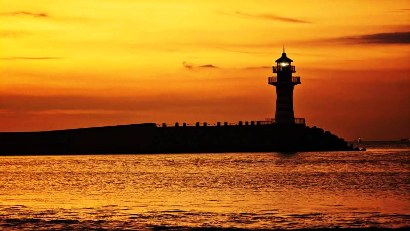 海南三亚清水湾朝霞满天中的自由灯塔剪影图片