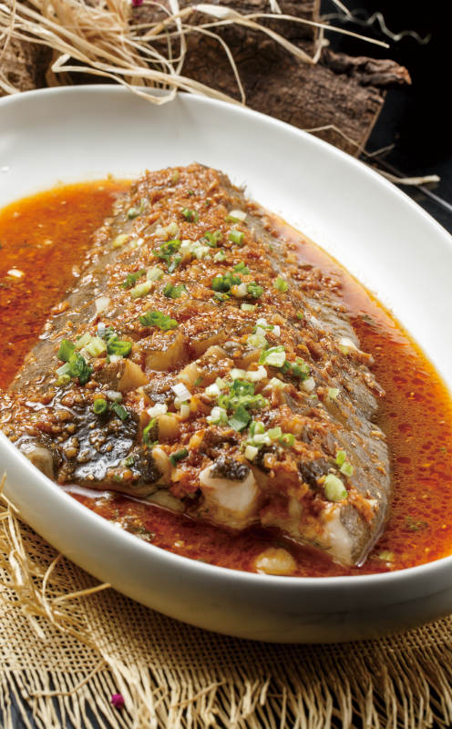 椭圆形白瓷盘装的深海鲽鱼尾图片