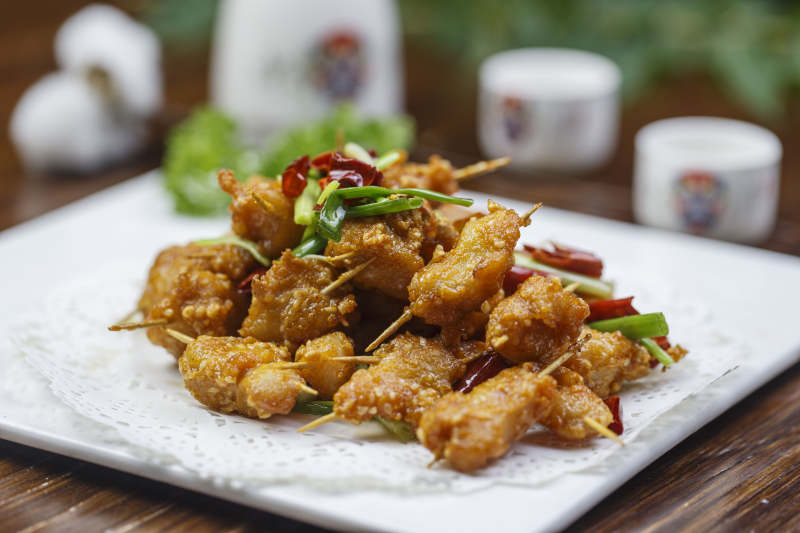 方形白色瓷盘装的香酥牙签肉图片