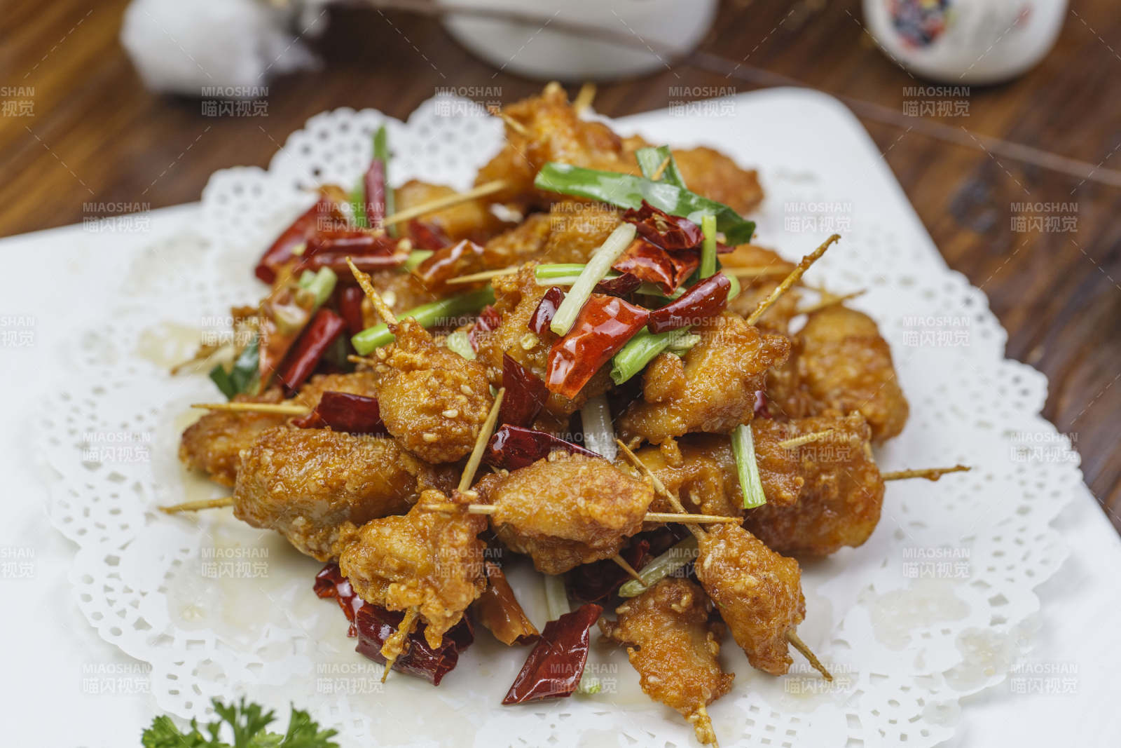 方形白色瓷盘装的香酥牙签肉图片