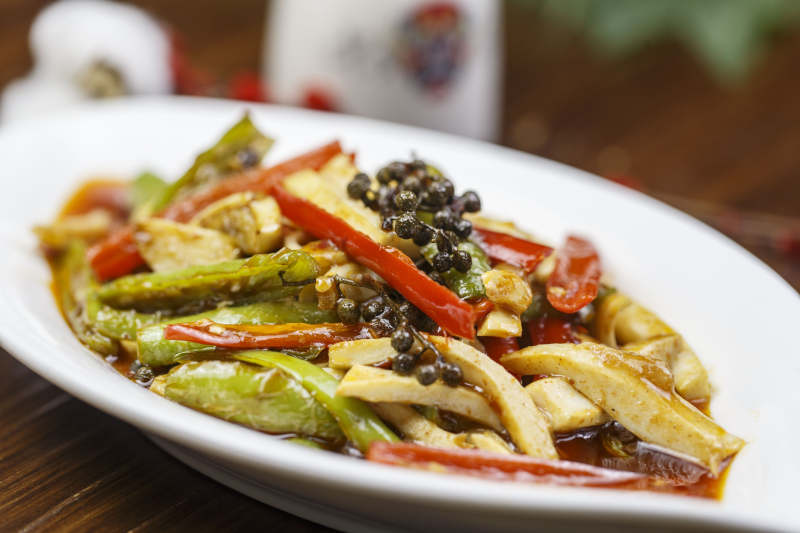 树叶形瓷盘装的椒麻尖椒烧干子图片