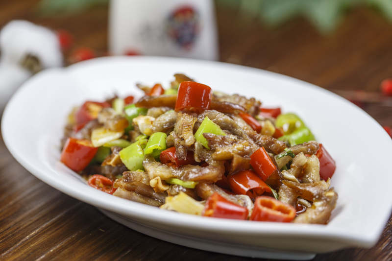 树叶形瓷盘装的湘味小炒猪儿五花肉图片