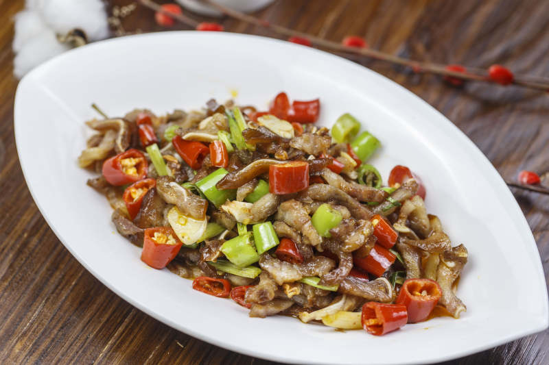 树叶形瓷盘装的湘味小炒猪儿五花肉图片