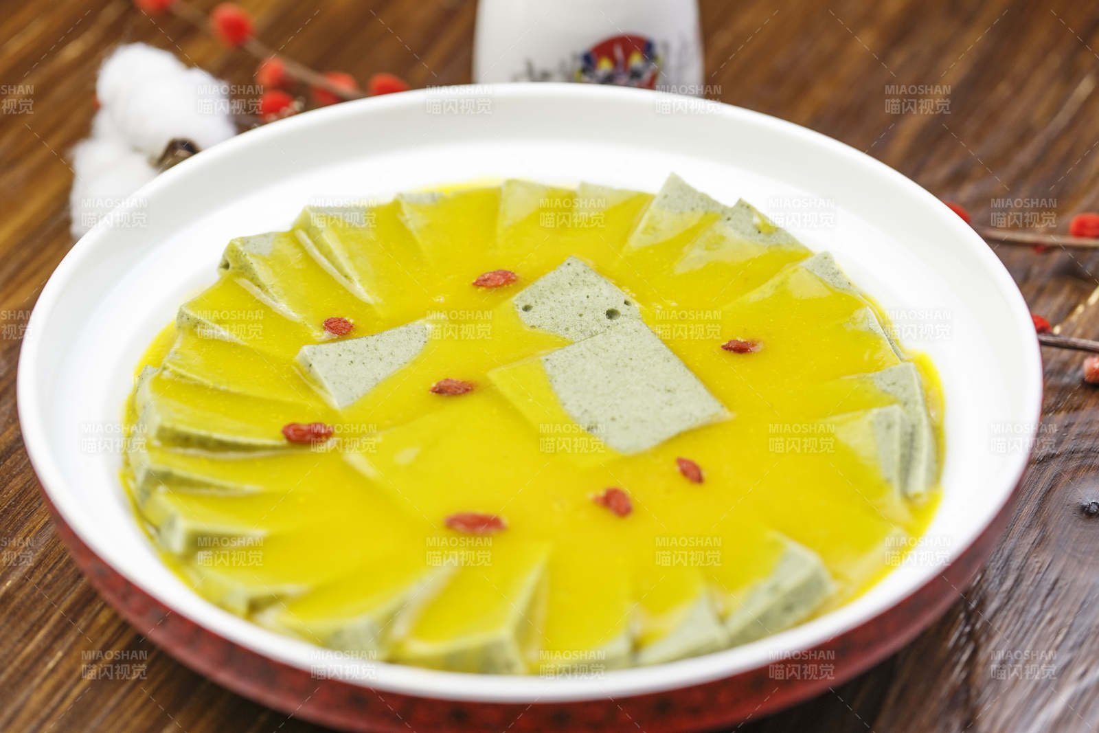 圆形白瓷盘装的浓汤枸杞麻豆腐黑豆腐图片