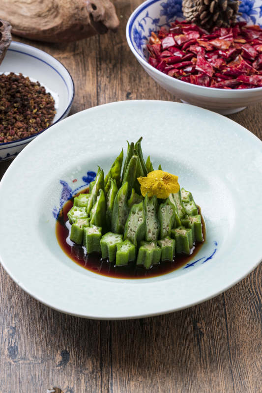 长方形白瓷盘装的浇汁凉拌秋葵图片