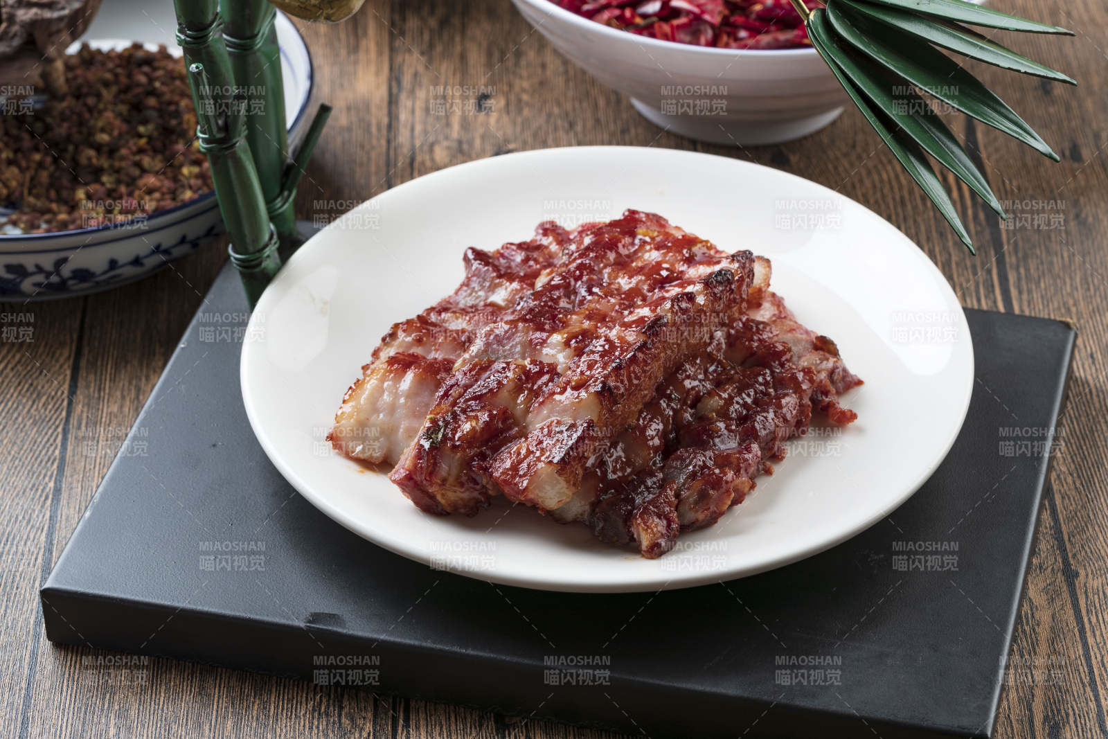 米花色瓷盘装的蜜汁叉烧肉摆放在樟木砧板上图片