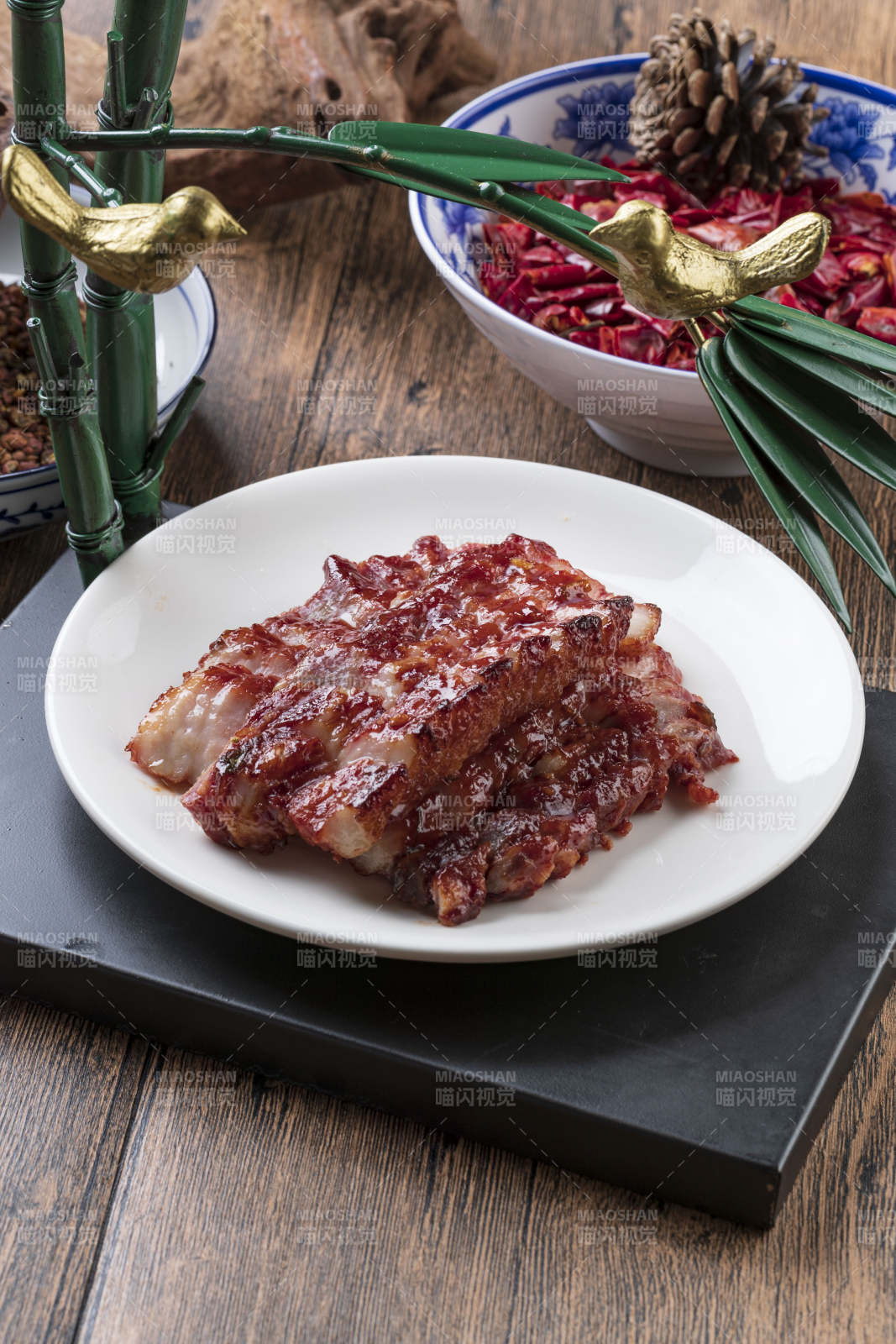 米花色瓷盘装的蜜汁叉烧肉摆放在樟木砧板上图片