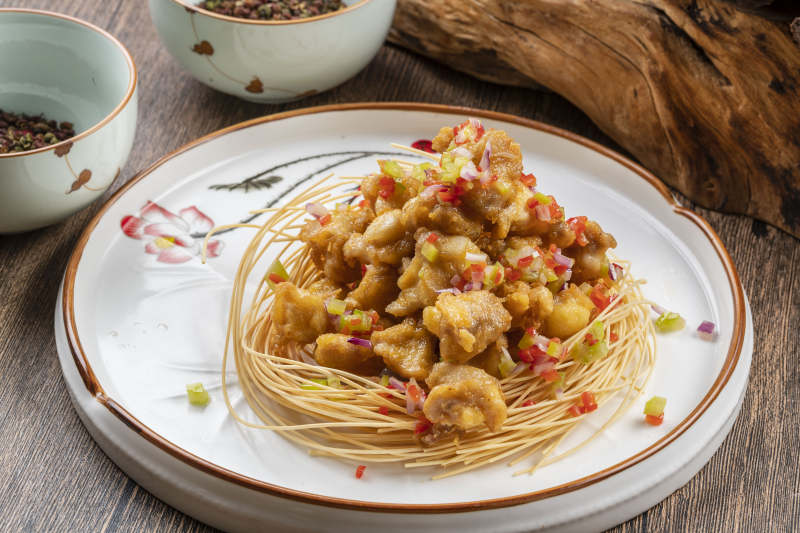 白色瓷盘装的香辣蒜香鸡块图片