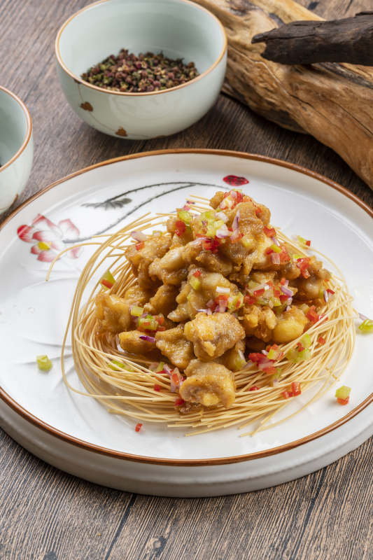 白色瓷盘装的香辣蒜香鸡块图片