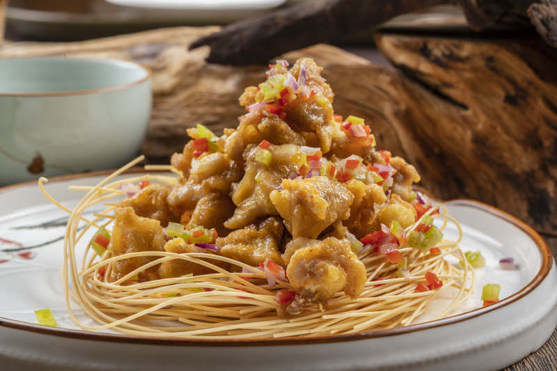 白色瓷盘装的香辣蒜香鸡块图片