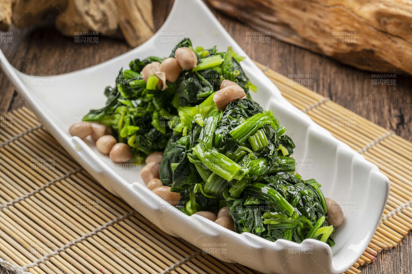 白色瓷盘装的果仁菠菜图片