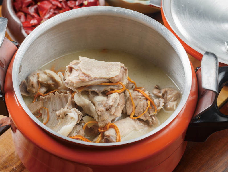 橙色不锈钢铁锅装的虫草花老鸭汤图片