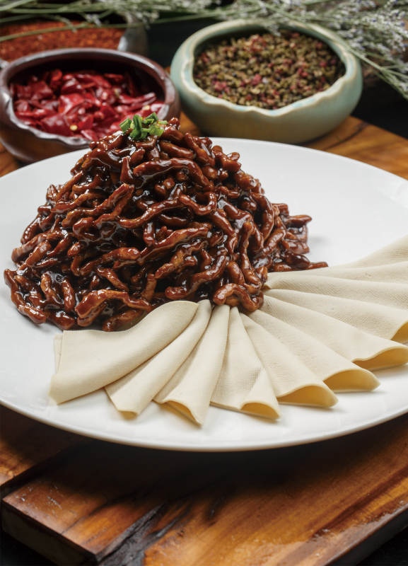 圆形白色瓷盘装的京酱肉丝图片