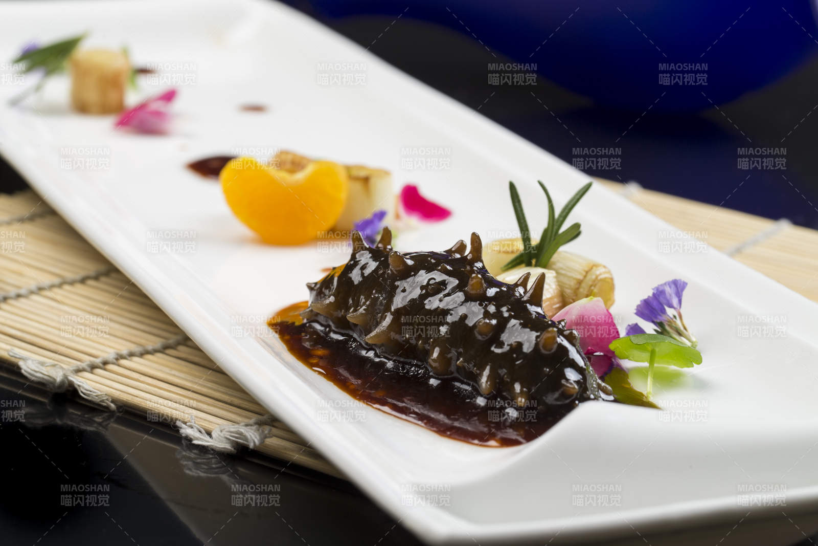 白色瓷盘装的葱烧海参图片