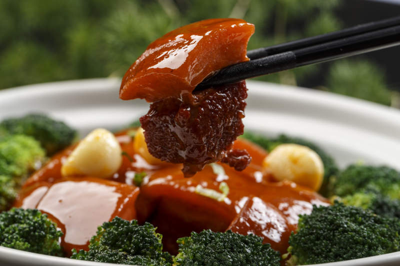 白色砂锅装的蒜香红烧肉图片