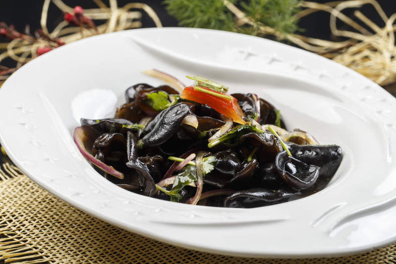 椭圆白色瓷盘装的芥末黑木耳图片