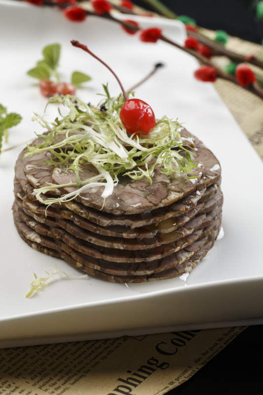 白色瓷盘装的五香压牛腱切片图片