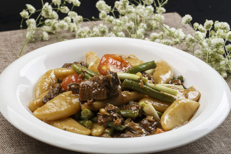 白色瓷盘装的豆角红烧肉炖山药鱼图片