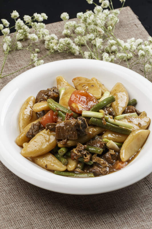 白色瓷盘装的豆角红烧肉炖山药鱼图片