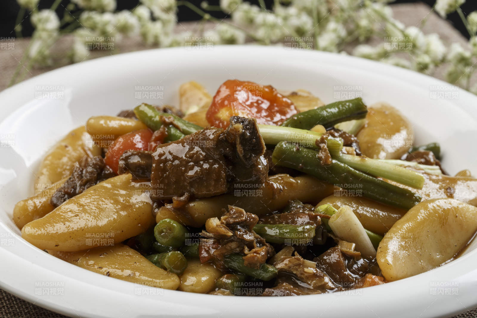 白色瓷盘装的豆角红烧肉炖山药鱼图片