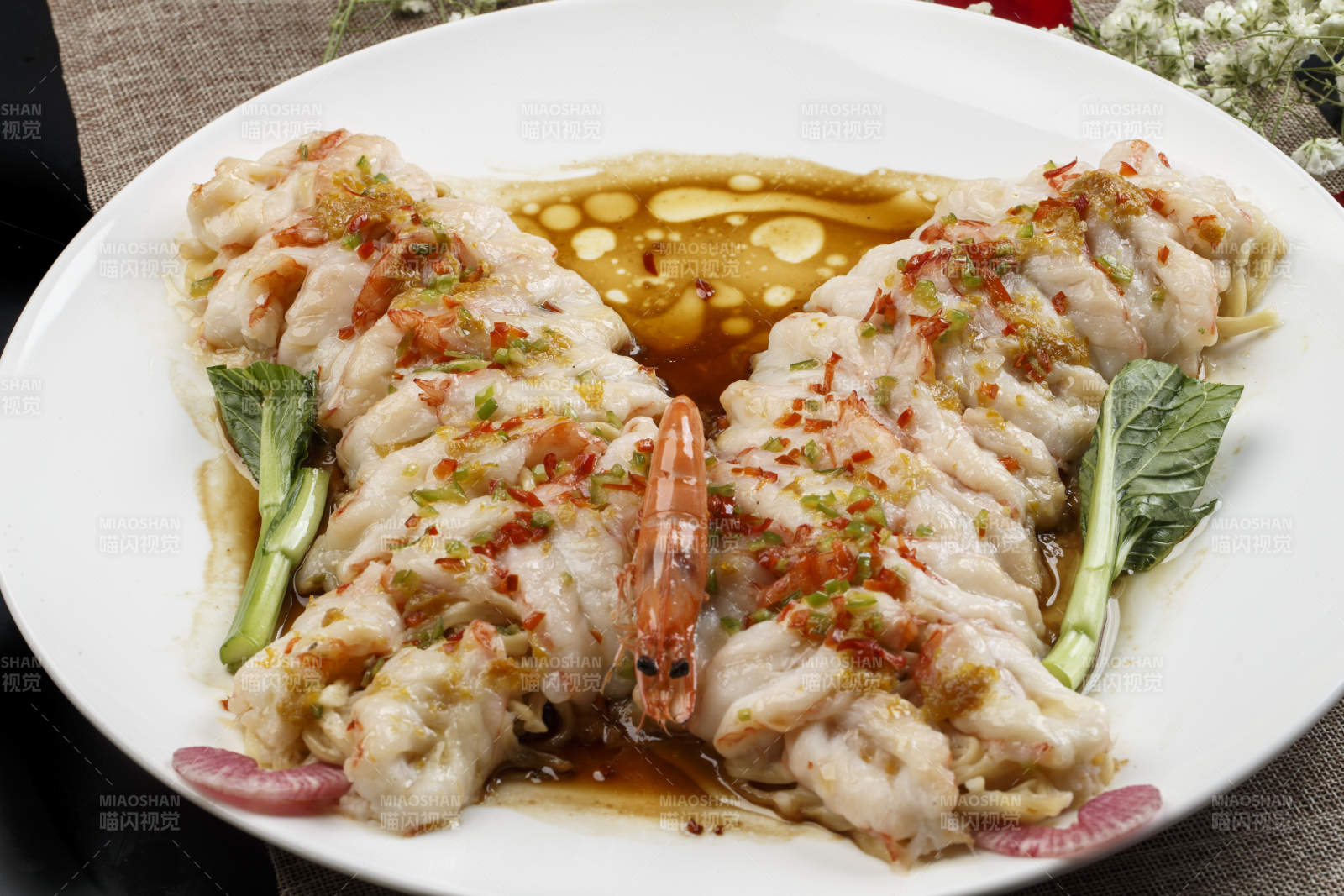 白色瓷盘装的浇汁蒜蓉蝴蝶虾图片
