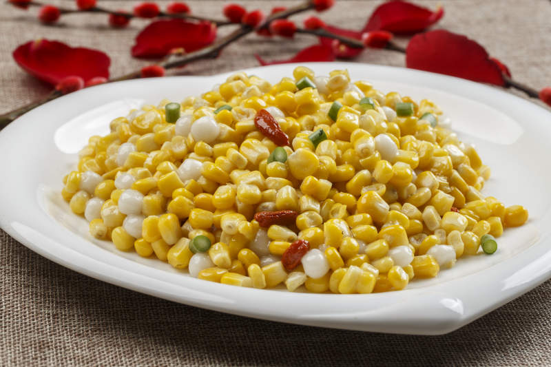 白色瓷盘装的松仁玉米图片